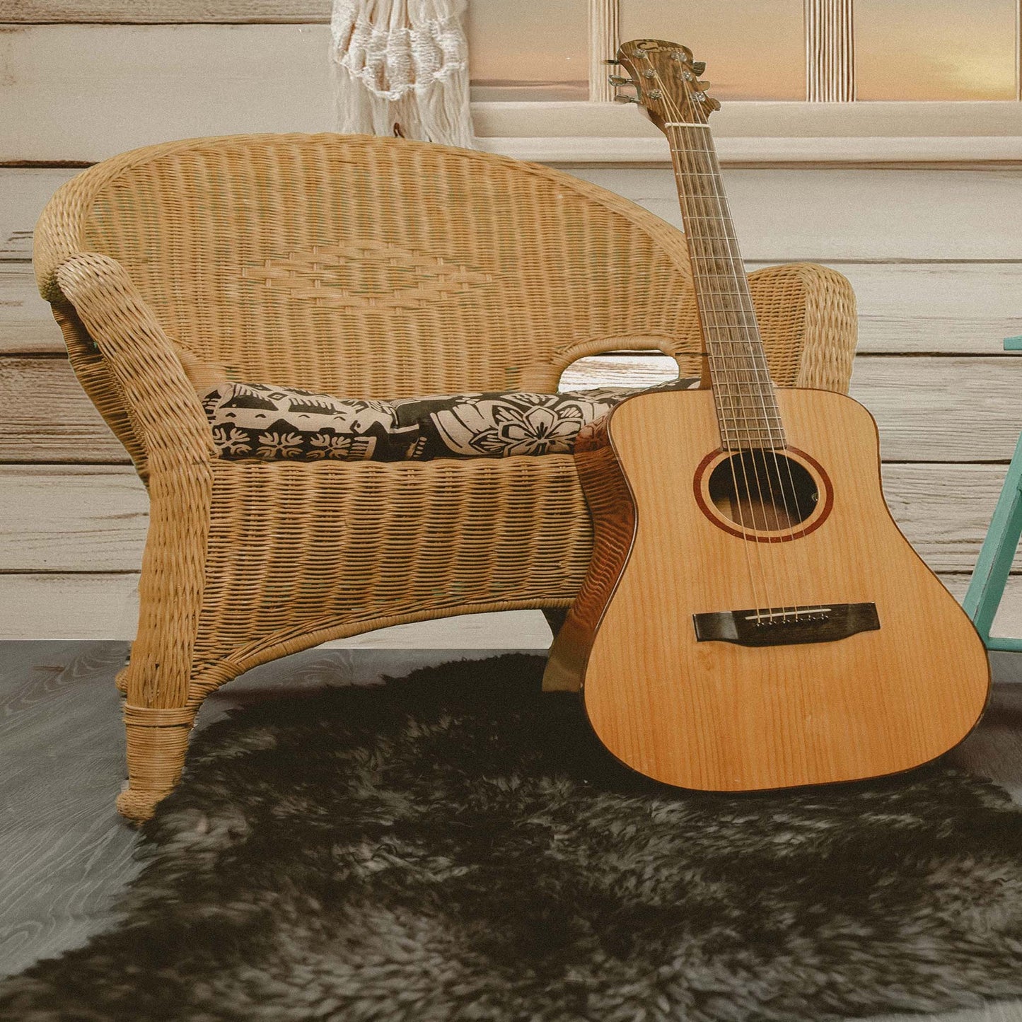 Boho Inspired Still Life with Acoustic Guitar, Wicker Chair, and Straw Hat
